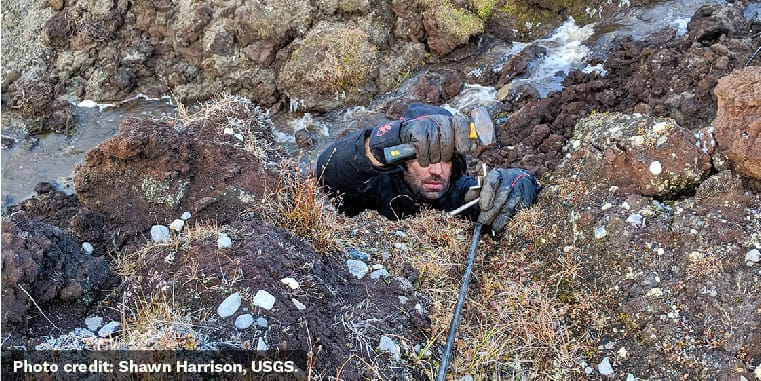 Ferdinand Oberle hammers a metal stake about a foot into the ground to anchor the ERT cable