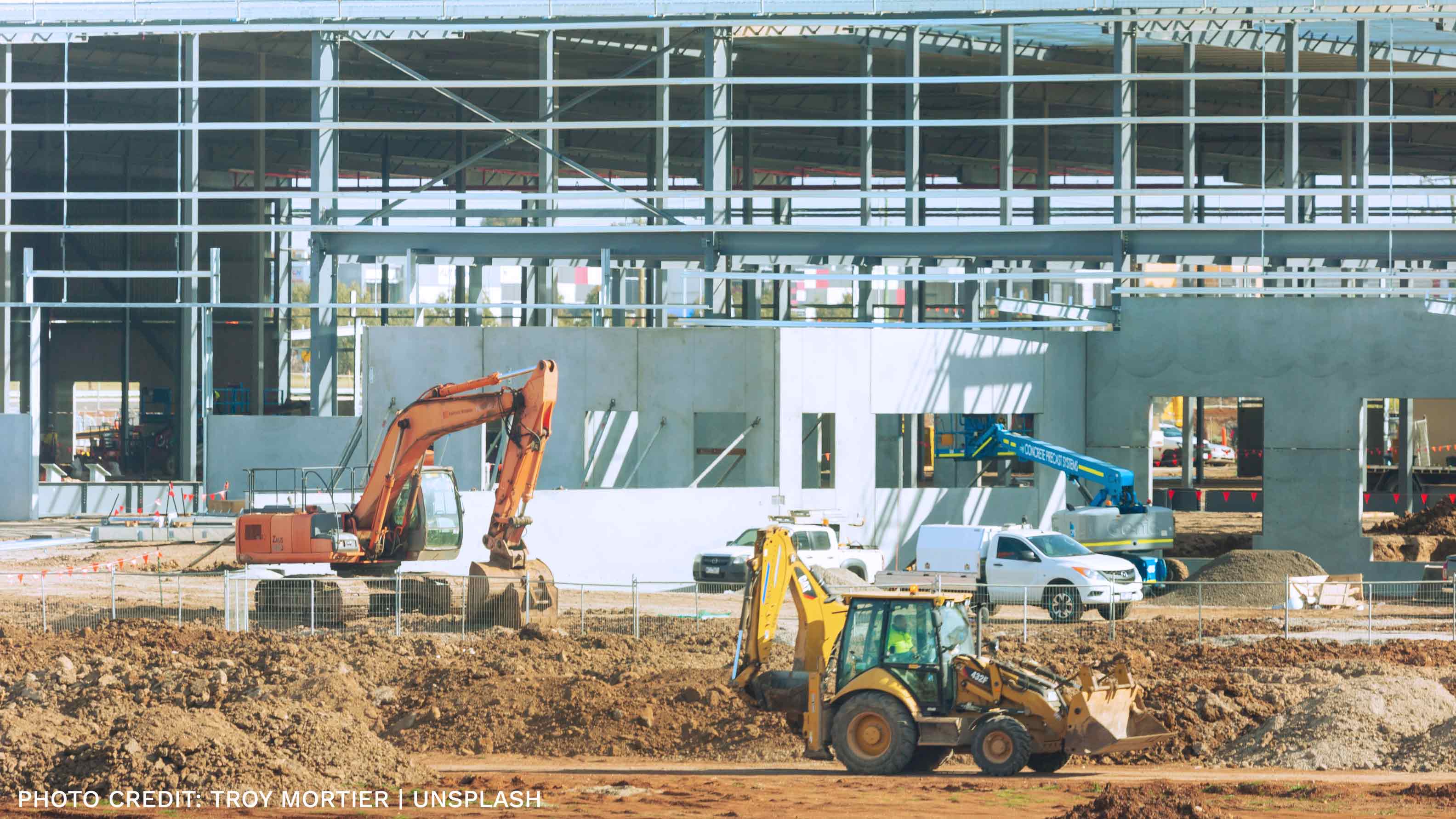 A construction site with an incomplete building in the background