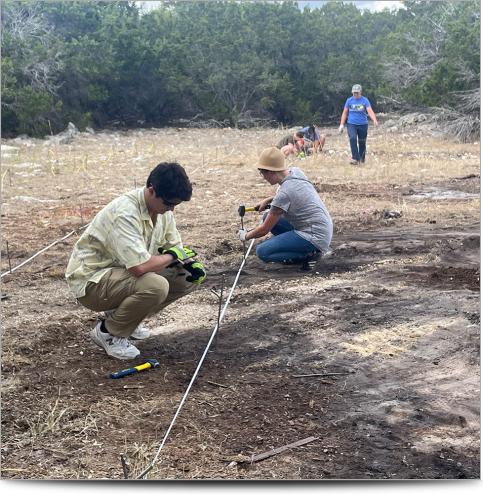 People hammering stakes into the ground for a resistivity survey