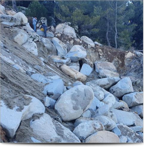 AGI Case History - Turkey Granite Mining Project - Workers carrying equipment over rocky terrain